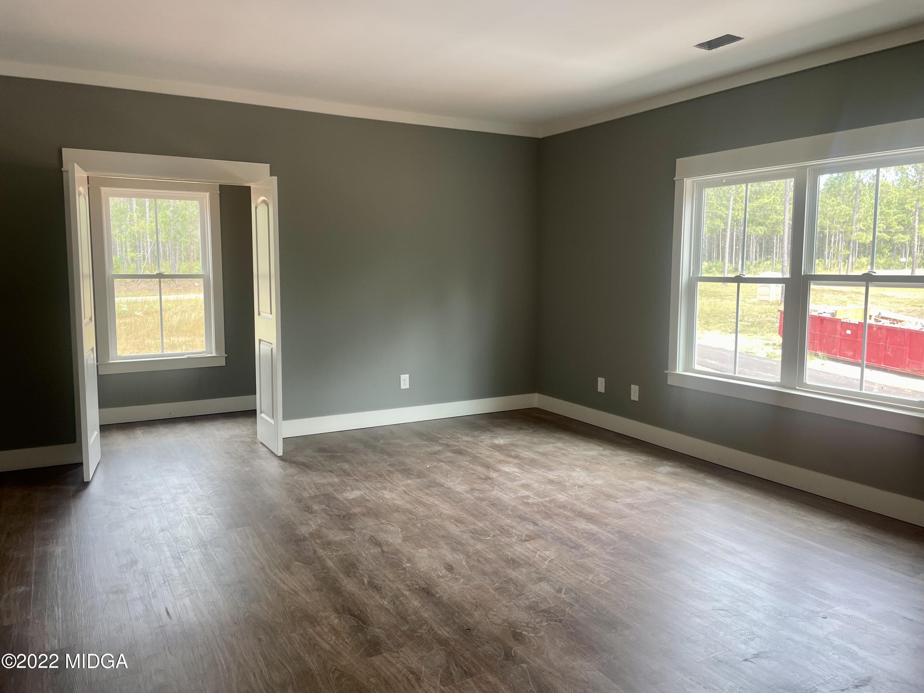 687 Edge Road Forsyth, GA 31029 - Photo 9 of 16 an empty room with wooden floor and windows