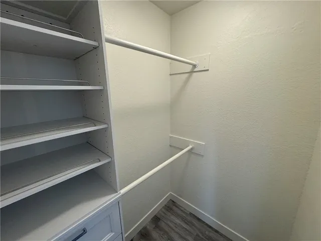 a view of walk in closet with empty racks