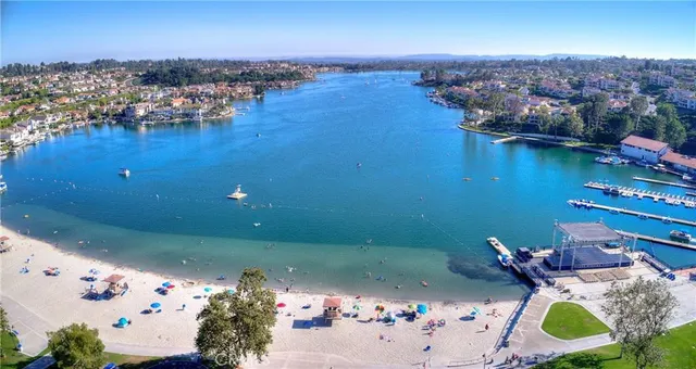 an aerial view of ocean and residential houses with outdoor space