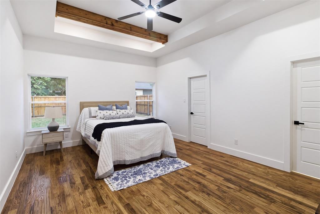 429 Waterboard Road Trinidad, TX 75163 - Photo 14 of 25 Spacious room featuring wood-finish flooring, a tray ceiling with exposed beam accent, and a ceiling fan