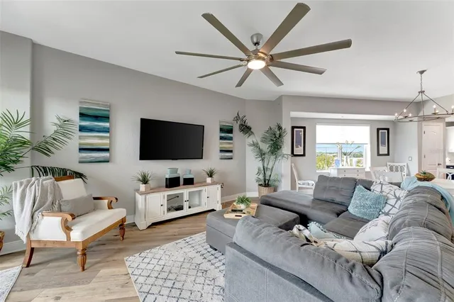 a living room with furniture a flat screen tv and a large window