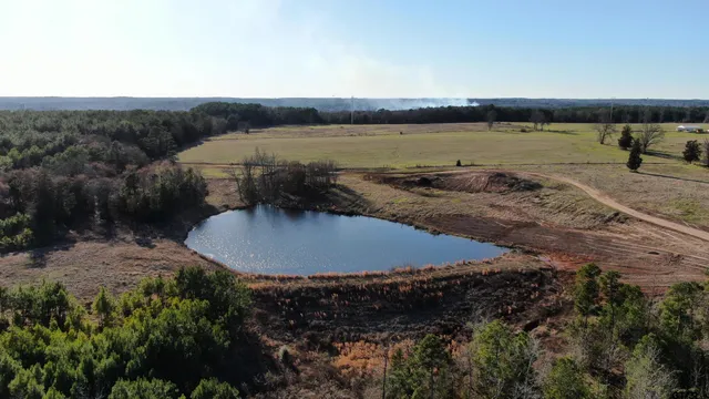 an aerial view of a house with a yard and lake view