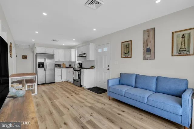 a living room with furniture and kitchen view