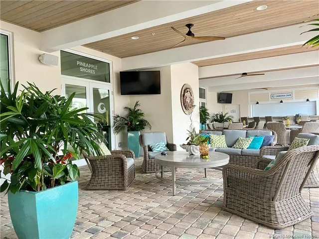 a living room with furniture pool table and a chandelier