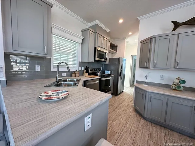 a kitchen with granite countertop a sink appliances and cabinets