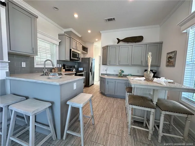a kitchen with a sink cabinets and wooden floor