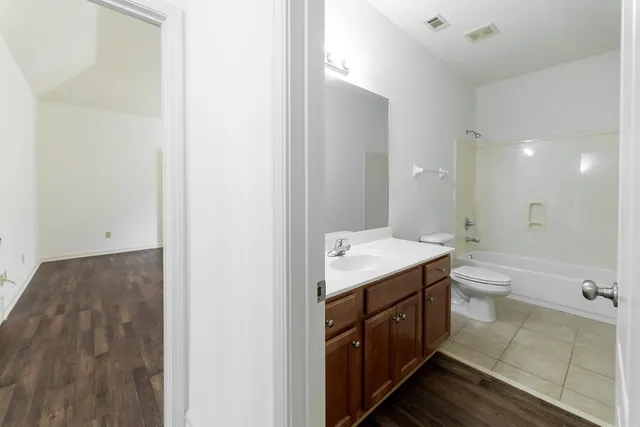 a bathroom with a granite countertop sink a toilet and shower