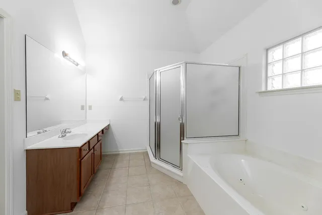 a bathroom with a tub sink and mirror