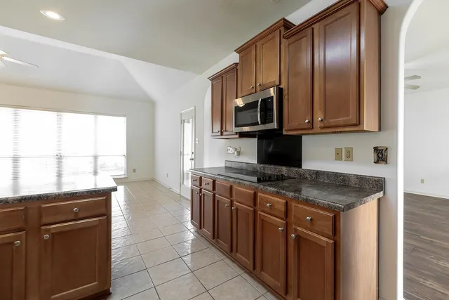 a kitchen with stainless steel appliances granite countertop a stove a sink and a microwave