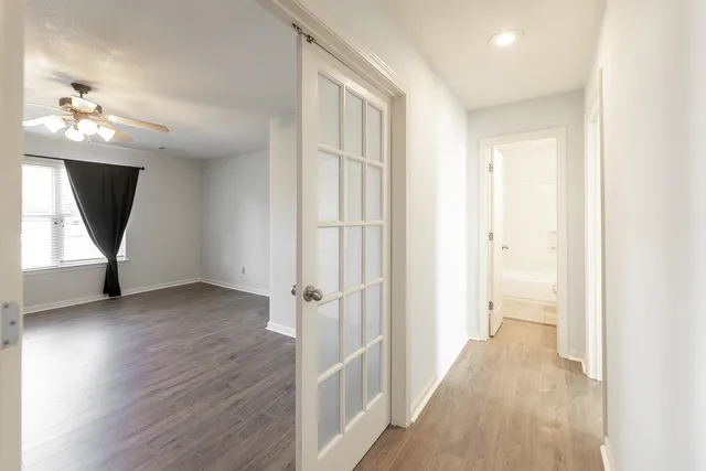 a view of a hallway with a window and wooden floor