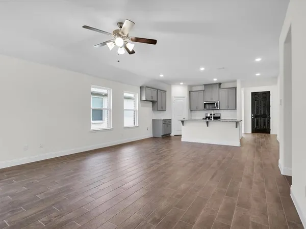 a view of a kitchen with a sink and dishwasher a refrigerator with wooden floor