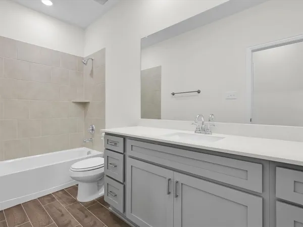 a bathroom with a sink toilet vanity and shower