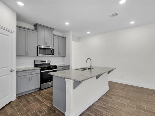 a kitchen with stainless steel appliances granite countertop a sink stove and refrigerator