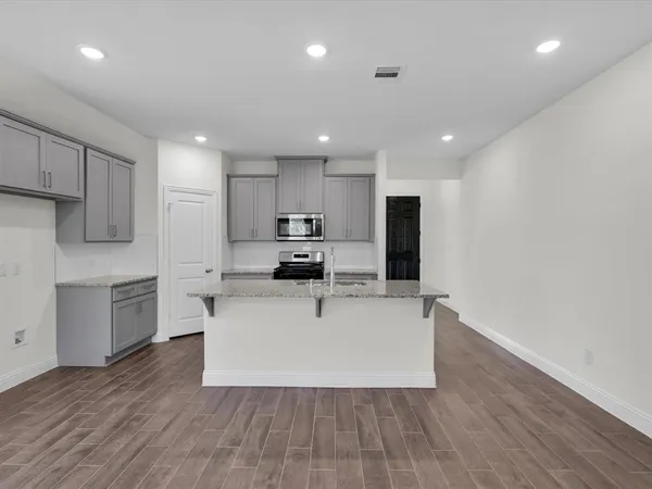 a view of kitchen with stainless steel appliances refrigerator sink and microwave