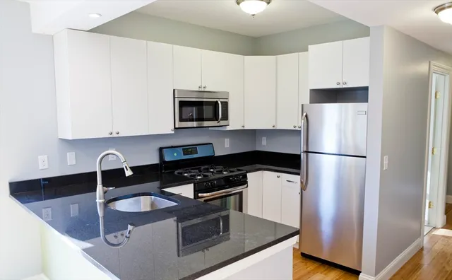 a kitchen with granite countertop a refrigerator stove and microwave
