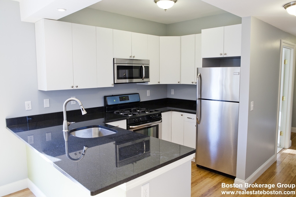 35 Forbes Street, Unit 2 Boston, MA 02130 - Photo 1 of 11 a kitchen with stainless steel appliances granite countertop a sink stove and refrigerator