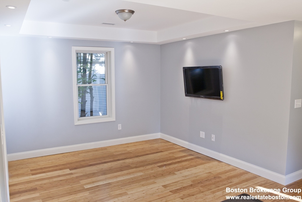 35 Forbes Street, Unit 2 Boston, MA 02130 - Photo 3 of 11 an empty room with wooden floor and windows