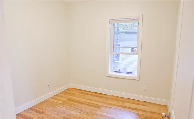 a view of a small space with wooden floor and a window