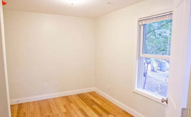 a view of a small space with wooden floor and a window