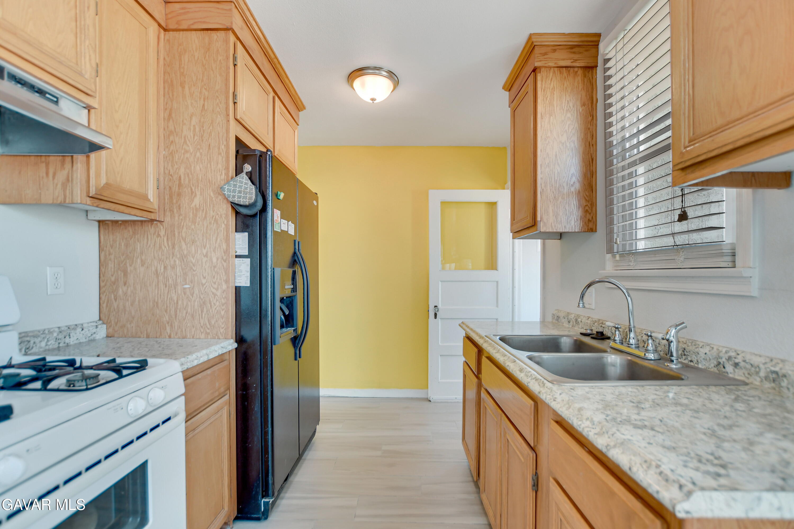 43517 7th Street East Lancaster, CA 93535 - Photo 10 of 47 a kitchen with a sink stove and refrigerator