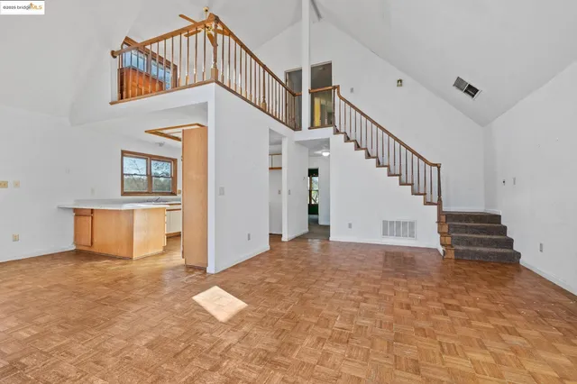a view of an empty room with stairs and a fireplace