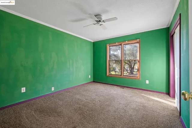 a view of a room with window and a ceiling fan