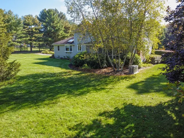 a view of a house with a big yard and large trees