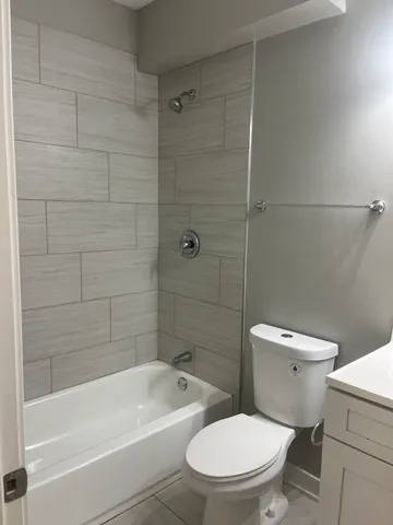a white toilet and tub sitting next to a bathroom sink