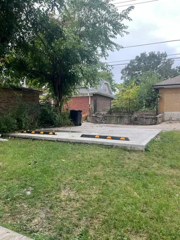 a front view of a house with garden and trees