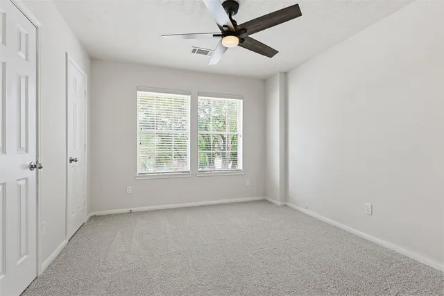a view of room with a ceiling fan and window