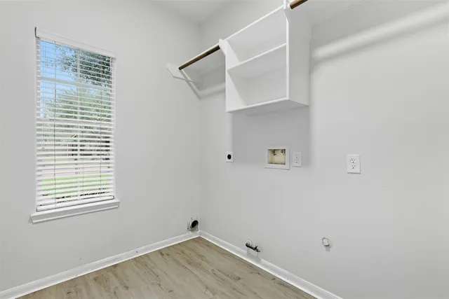 a view of a room that has a window and wooden floor