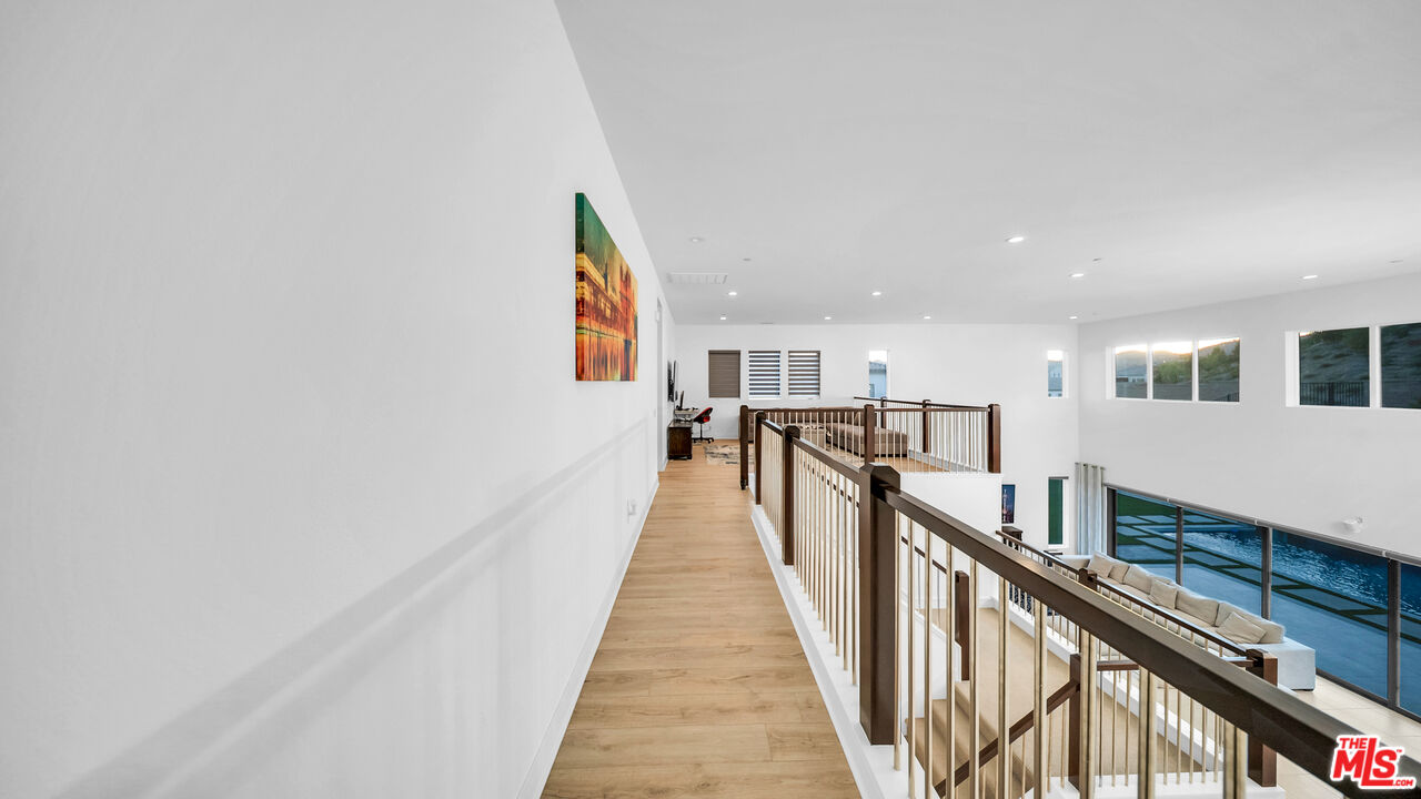 12553 Ridgeline Road Porter Ranch, CA 91326 - Photo 21 of 45 a view of a hallway with wooden floor and staircase