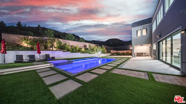 a view of yard with swimming pool and green space