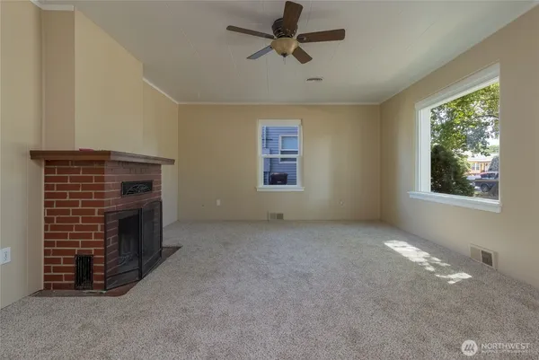 a view of an empty room with a fireplace and a window