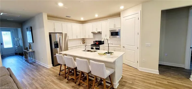 a kitchen with a table chairs refrigerator and microwave