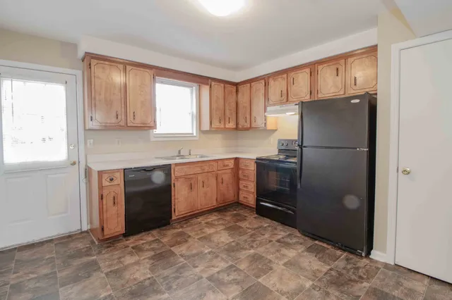 a kitchen with a refrigerator sink and cabinets