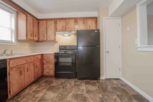 a kitchen with granite countertop a refrigerator and a sink