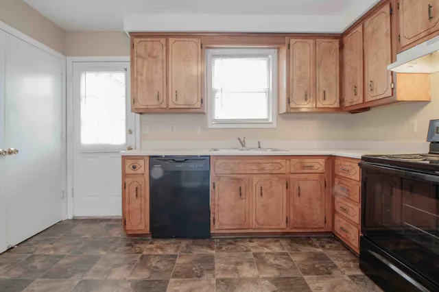 a kitchen with granite countertop a stove a sink and a cabinets