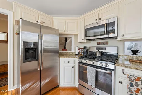 a kitchen with stainless steel appliances granite countertop a refrigerator and a stove top oven