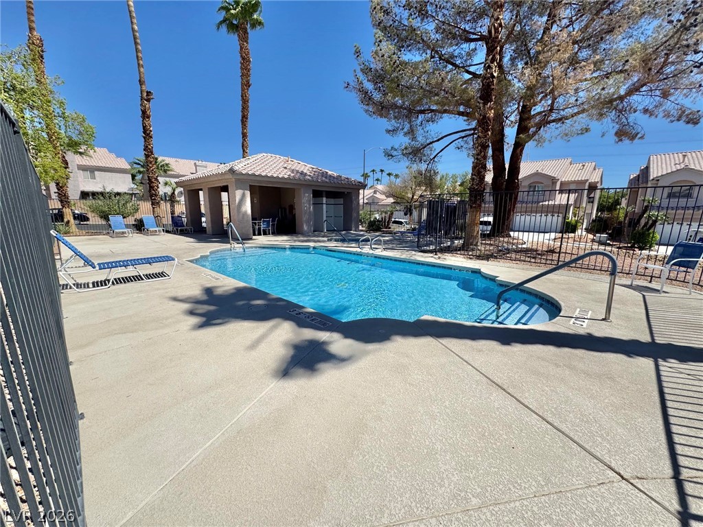 5304 Runningbrook Road Las Vegas, NV 89120 - Photo 21 of 22 Sun-drenched concrete decking surrounds a sparkling community pool bordered by tropical palm trees.