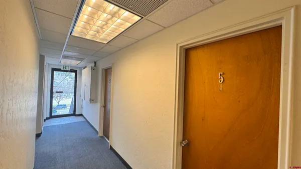 a view of a hallway with wooden shelves