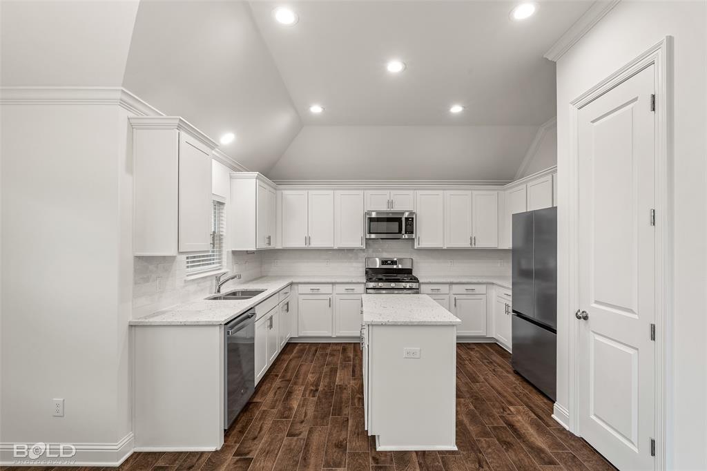 304 Prien Lk Loop Bossier City, LA 71111 - Photo 17 of 39 Bright kitchen featuring white cabinetry, wood-finish flooring, recessed lighting, and stainless steel appliances including a built-in microwave and range