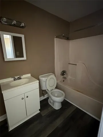 a bathroom with a granite countertop toilet sink and mirror