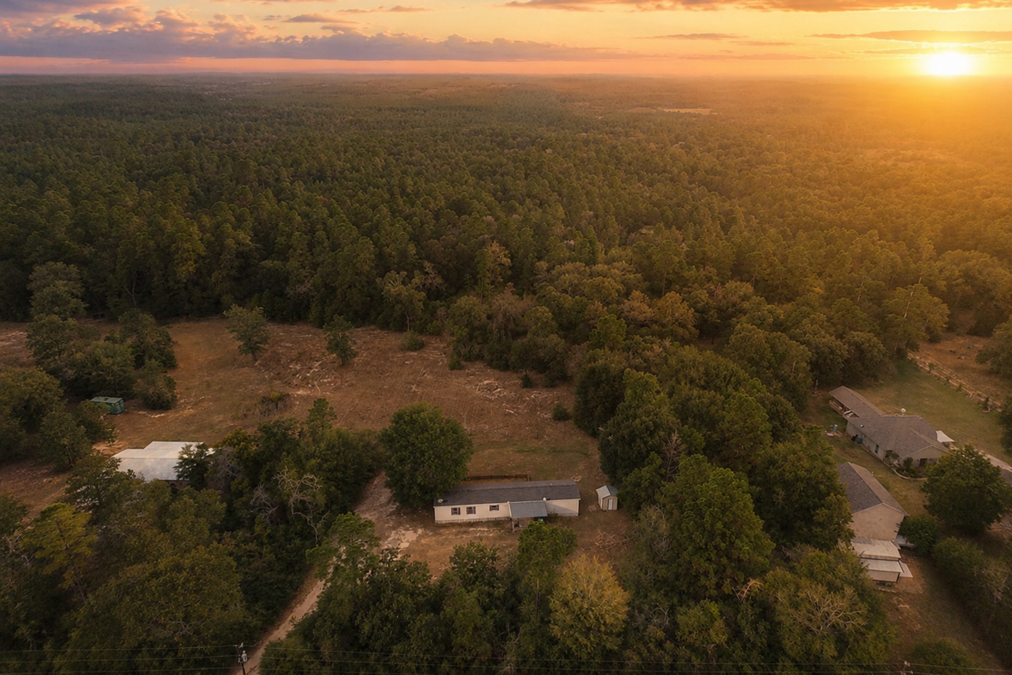6493 Pappas Road Waller, TX 77484 - Photo 1 of 32 Sunset Aerial view of this 2.32-acre private retreat in West Magnolia Forest, Waller TX, featuring mature trees and expansive open space.