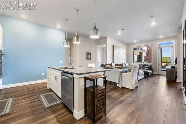 a kitchen with stainless steel appliances a dining table chairs and refrigerator