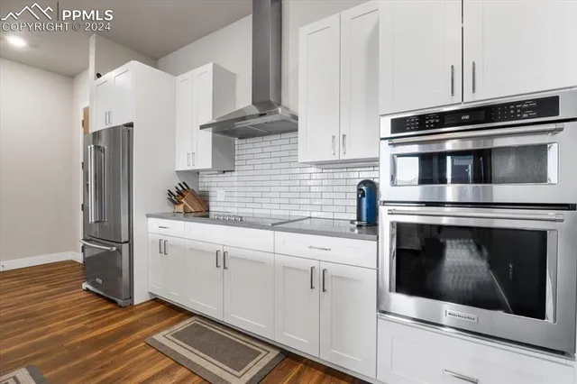 a large kitchen with cabinets and wooden floor