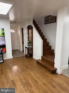 a view of a livingroom with wooden floor and stairs