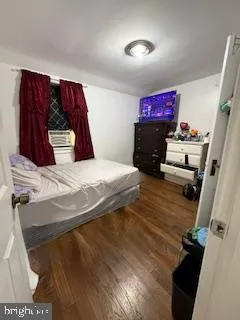 a bedroom with a bed and a flat tv screen on the dresser