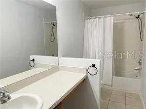 a bathroom with a tub sink and mirror