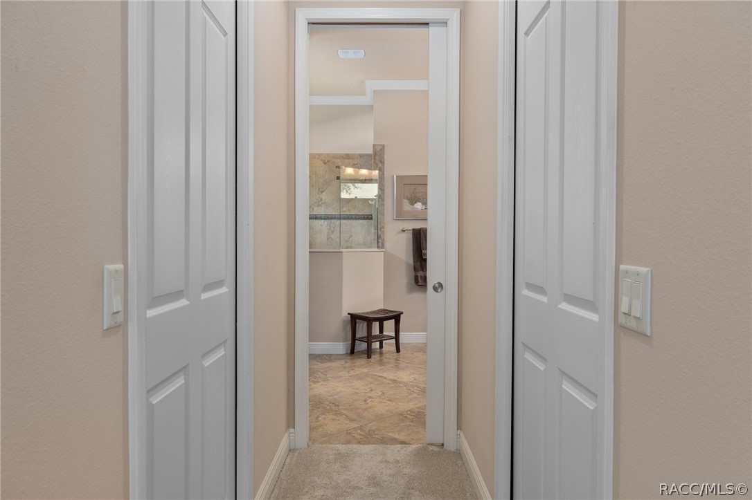 2015 North Rhodes Point Hernando, FL 34442 - Photo 21 of 82 Hallway leading into Primary Bath is flanked by two walk-in closets, each with a pocket door.